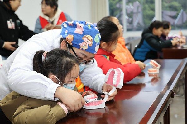 图为口腔医生指导“小牙医”正确刷牙。唐侃摄