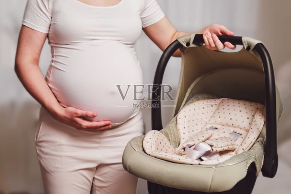 婴儿汽车座椅在孕妇，家庭客厅照片摄影图片