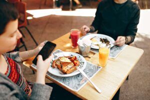 Two people enjoy a balanced breakfast at a café, showing how a registered dietitian in Raleigh, NC supports real-life eating experiences through eating disorder therapy in Raleigh, NC.