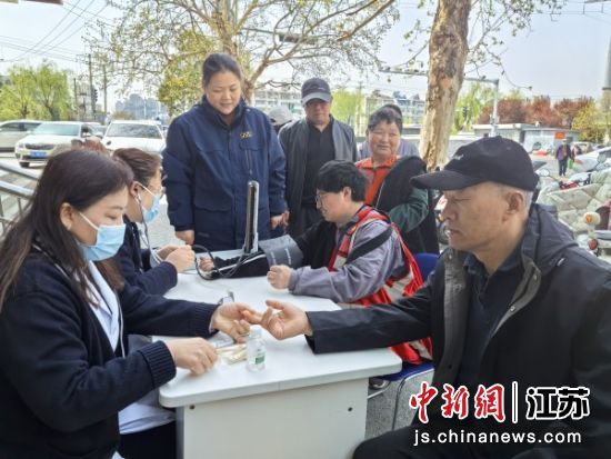 医护志愿者为快递员和辖区居民量血压、测血糖。孙雪纯 摄