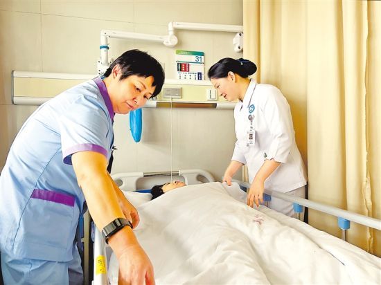 在郑州市中心医院脊柱外科病房，护士和医疗护理员正在照料患者。