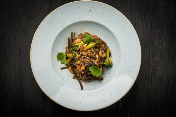 俯视图素食荞麦面与海带，腰果和花椰菜在黑色的乡村木材照片摄影图片