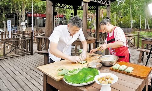 5月31日一大早，在邢台市信都区羊范镇北唐村语荷餐厅，工作人员正在用焯水的荷叶包粽子。 本报记者 吕若汐摄