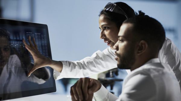 Medical team in white lab coats looking at data