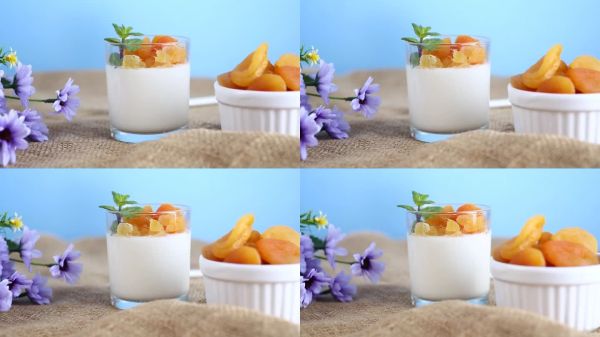 藍(lán)色背景上的輕盈水果酸奶配干杏。