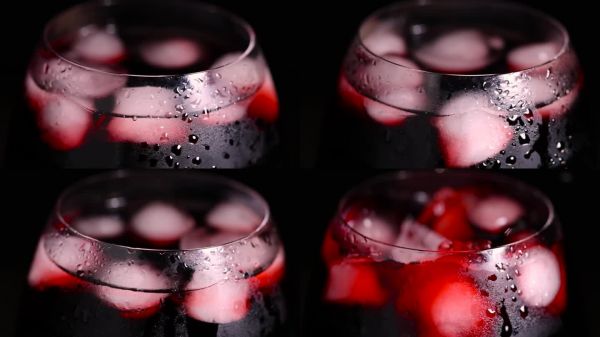 红色冷饮在装有冰块的玻璃杯中。