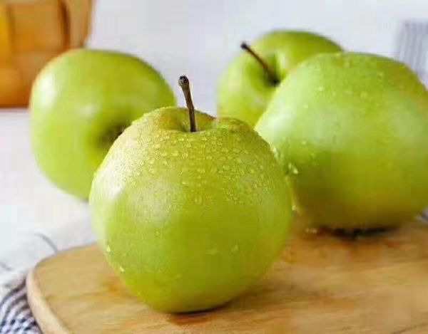 新鮮雪梨與橙子擺放在木質(zhì)砧板上，旁邊有刀具和量杯