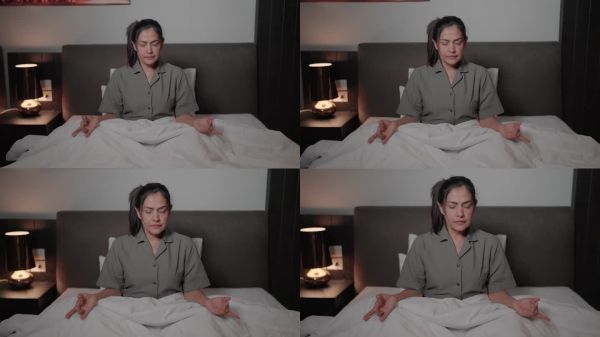 平静健康的女人在舒适的床上放松。在家里的休息室里打个盹，感觉没有压力。