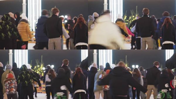 人們在街頭冰場上滑冰，享受圣誕假期的夜晚?；盍λ纳涞墓?jié)日氣氛。