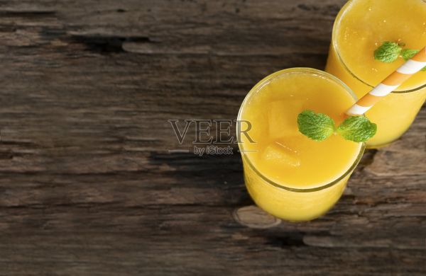 芒果冰沙黄色的彩色果汁奶昔混合饮料健康高蛋白的味道美味的在玻璃饮料减肥饮料集早上在一个木制的背景从俯视图。照片摄影图片