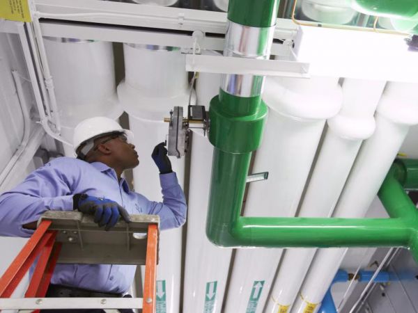 Man looking at a pipe and operating