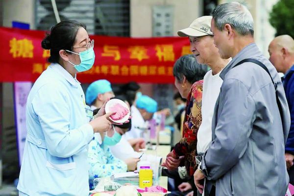 醫(yī)院護(hù)士為居民進(jìn)行健康飲食指導(dǎo)