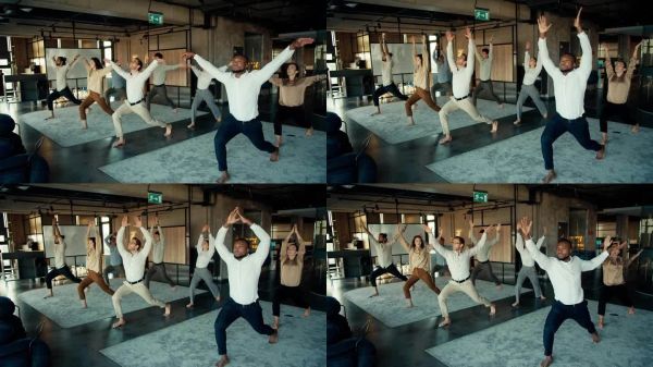 国际团队在办公室工作间隙做瑜伽。工人们保持身心健康