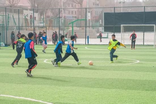 2月27日，孩子们正在和田体育中心内的绿茵场上踢足球。伊尔番 摄