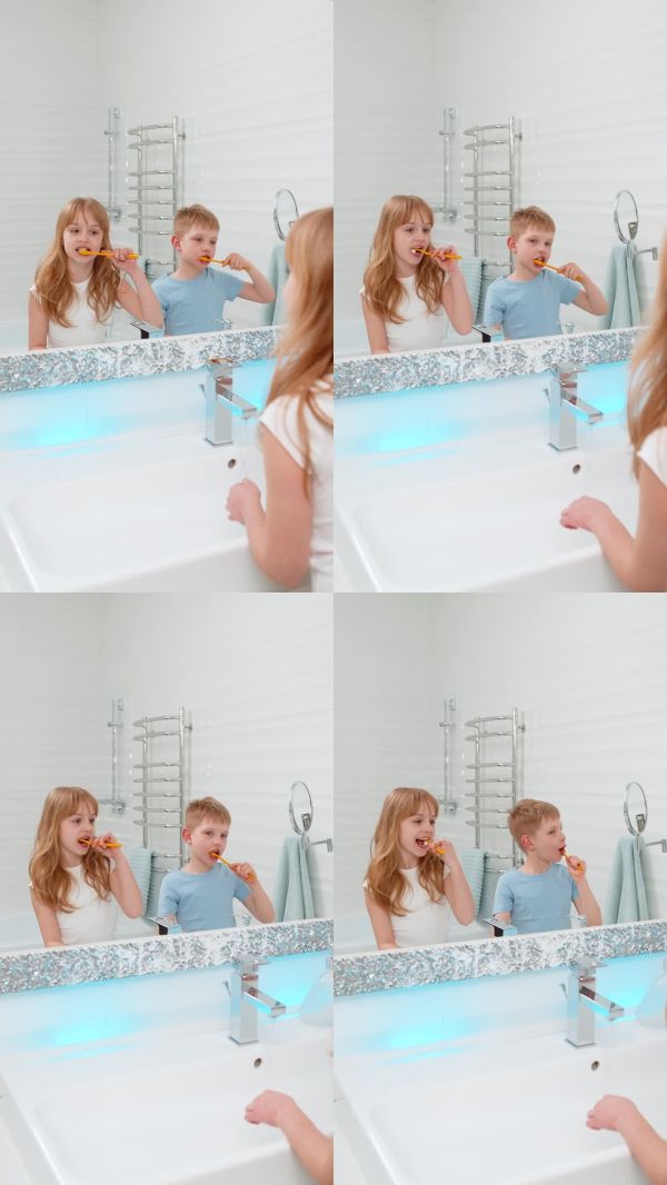 男孩女孩在浴室里一起刷牙，面对镜子，早晨的卫生和牙齿健康护理。