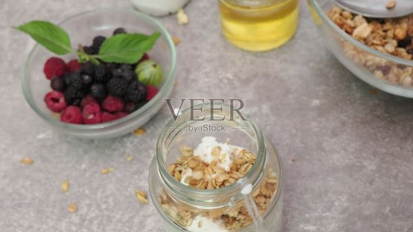 健康的早餐，包含酸奶、燕麦、野莓、覆盆子、蓝莓和蜂蜜，是富含蛋白质的饮食、均衡营养和减肥餐的理想选择。健康早餐健身餐。照片摄影图片