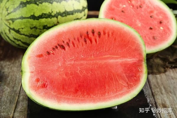 西瓜切块特写：新鲜红瓤西瓜去皮后切成均匀三角块，果肉饱满多汁，表面泛自然水光，背景为白色陶瓷盘与浅灰亚麻布，无添加糖浆或装饰