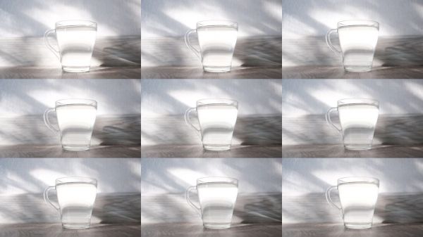 玻璃杯中的纯净水，阳光在水中折射。清晨，开启新的一天。饮水以防脱水，控制体重，养成健康习惯。保持水分