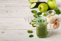 新鲜的绿色果蔬奶昔，以健康的生活方式和原料制作膳食饮料(菠菜，青苹果，黄瓜，燕麦)。排毒。副本的空间。有选择性的重点图片