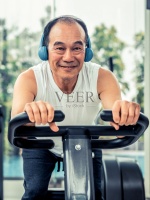 老年人在健身中心的自行车机上锻炼。成熟健康的生活方式。图片